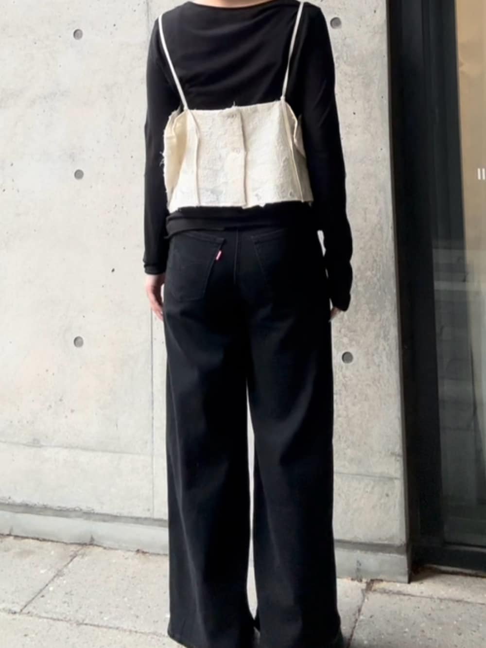 ブラック系のTシャツ/カットソー、ホワイト系のキャミソール、ブラック系のデニムパンツを着用したレディースの秋コーディネートの3枚目の写真