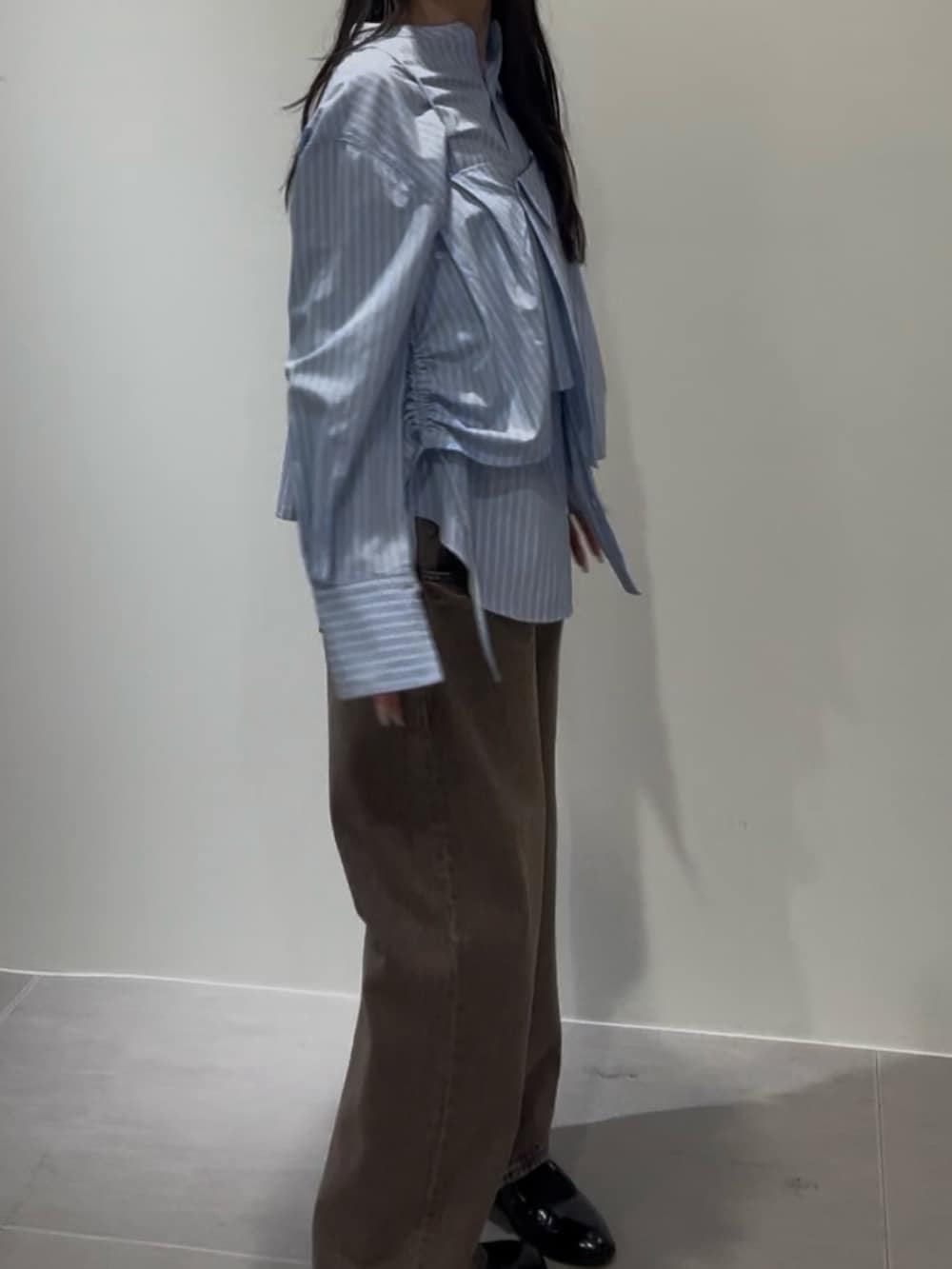 ブルー系のシャツ/ブラウス、ブラウン系のデニムパンツ、ブラック系のローファーを着用したレディースの冬コーディネートの3枚目の写真