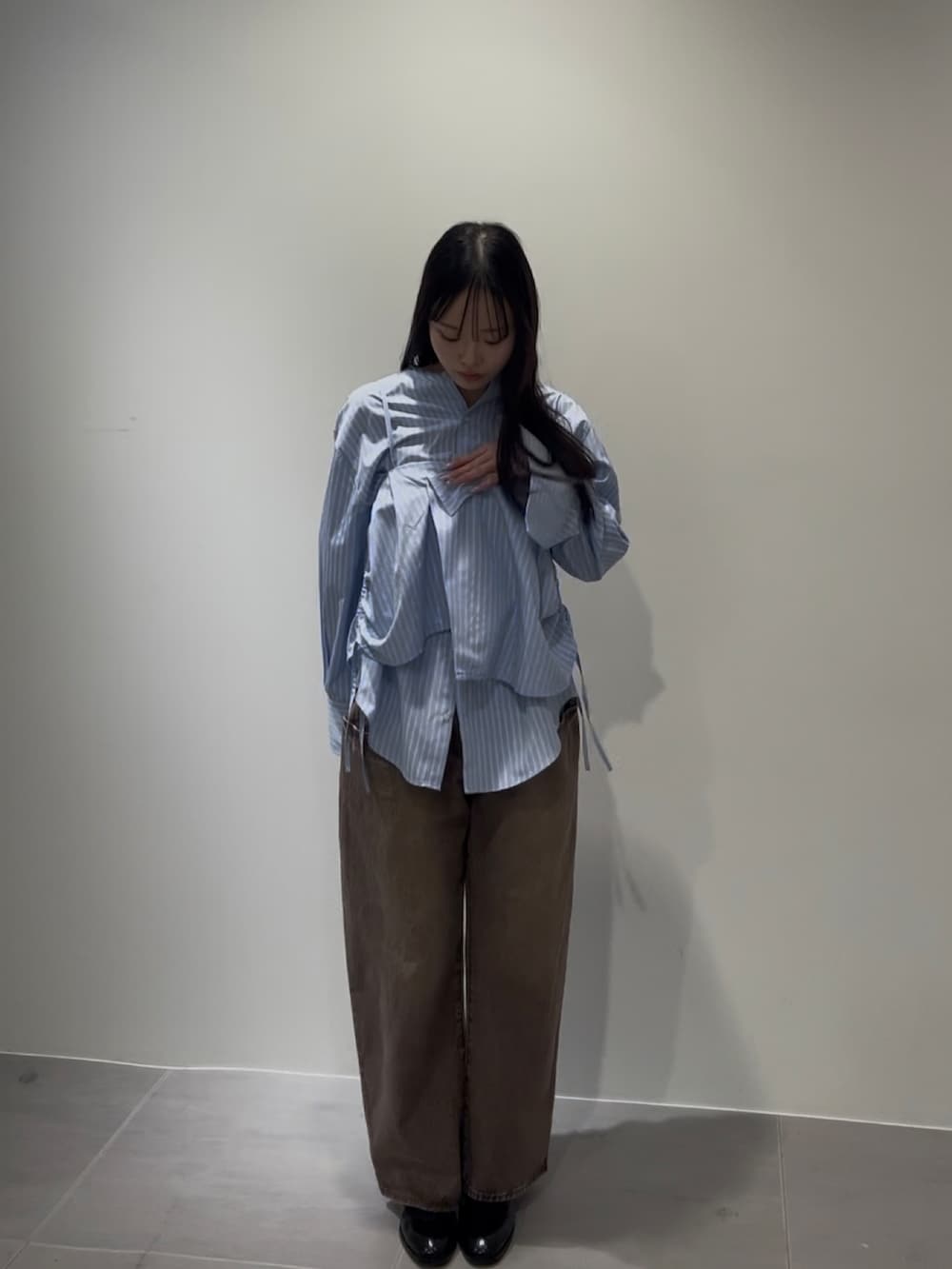 ブルー系のシャツ/ブラウス、ブラウン系のデニムパンツ、ブラック系のローファーを着用したレディースの冬コーディネートの2枚目の写真