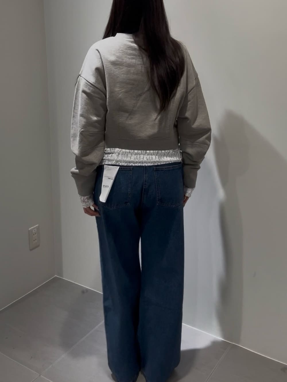 ベージュ系のスウェット、ホワイト系のTシャツ/カットソー、ブルー系のデニムパンツを着用したレディースの冬コーディネートの3枚目の写真