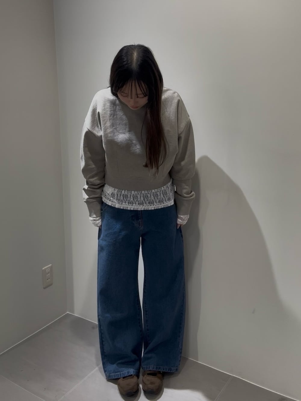 ベージュ系のスウェット、ホワイト系のTシャツ/カットソー、ブルー系のデニムパンツを着用したレディースの冬コーディネートの2枚目の写真