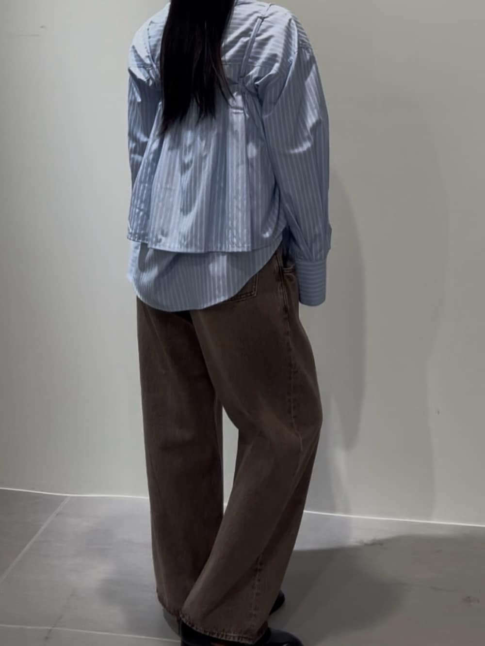 ブルー系のシャツ/ブラウス、ブラウン系のデニムパンツ、ブラック系のローファーを着用したレディースの冬コーディネートの4枚目の写真