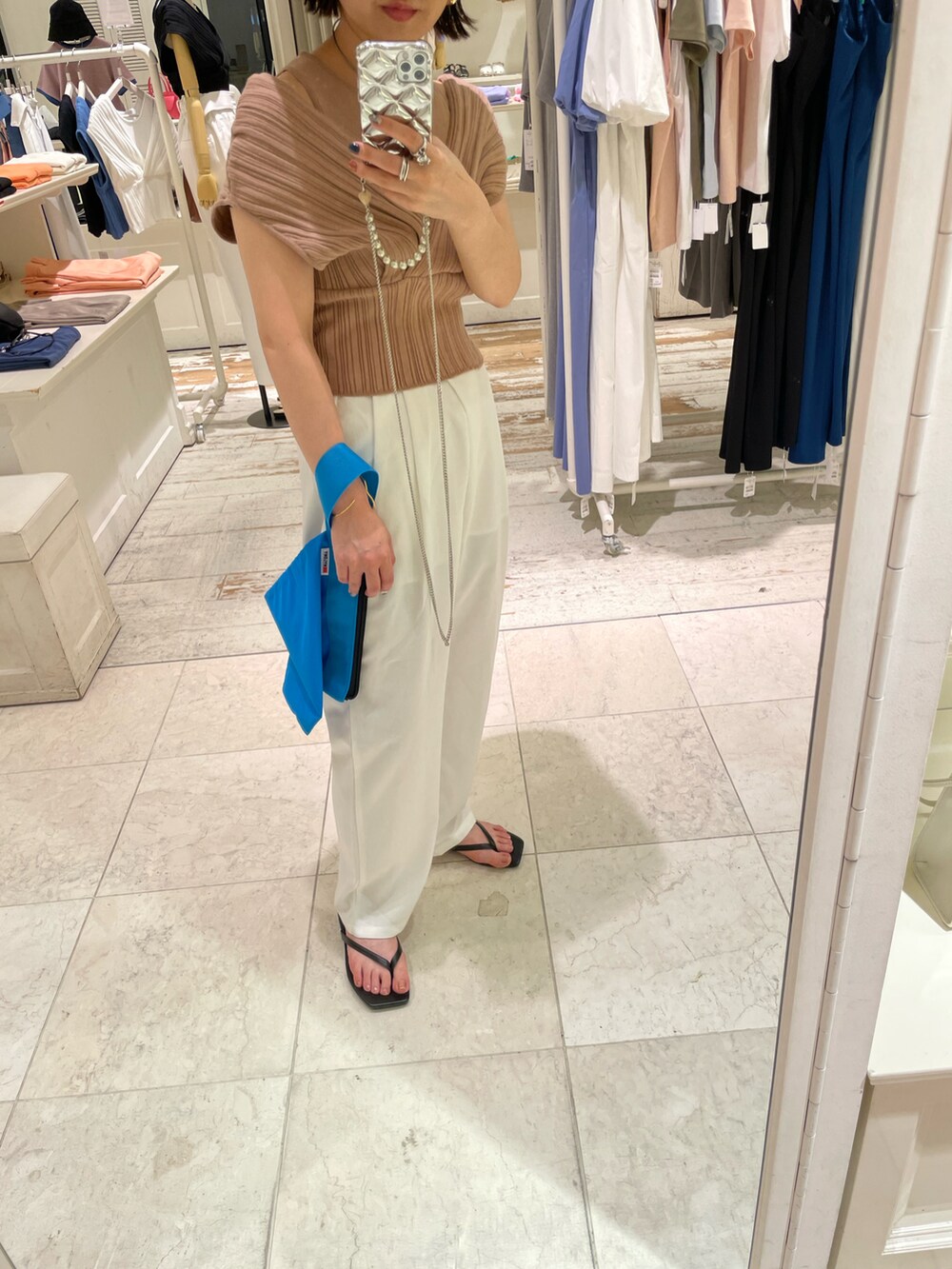 イエロー系のニット/セーター、ホワイト系のその他パンツ、ブルー系のハンドバッグを着用したレディースの夏コーディネートの3枚目の写真