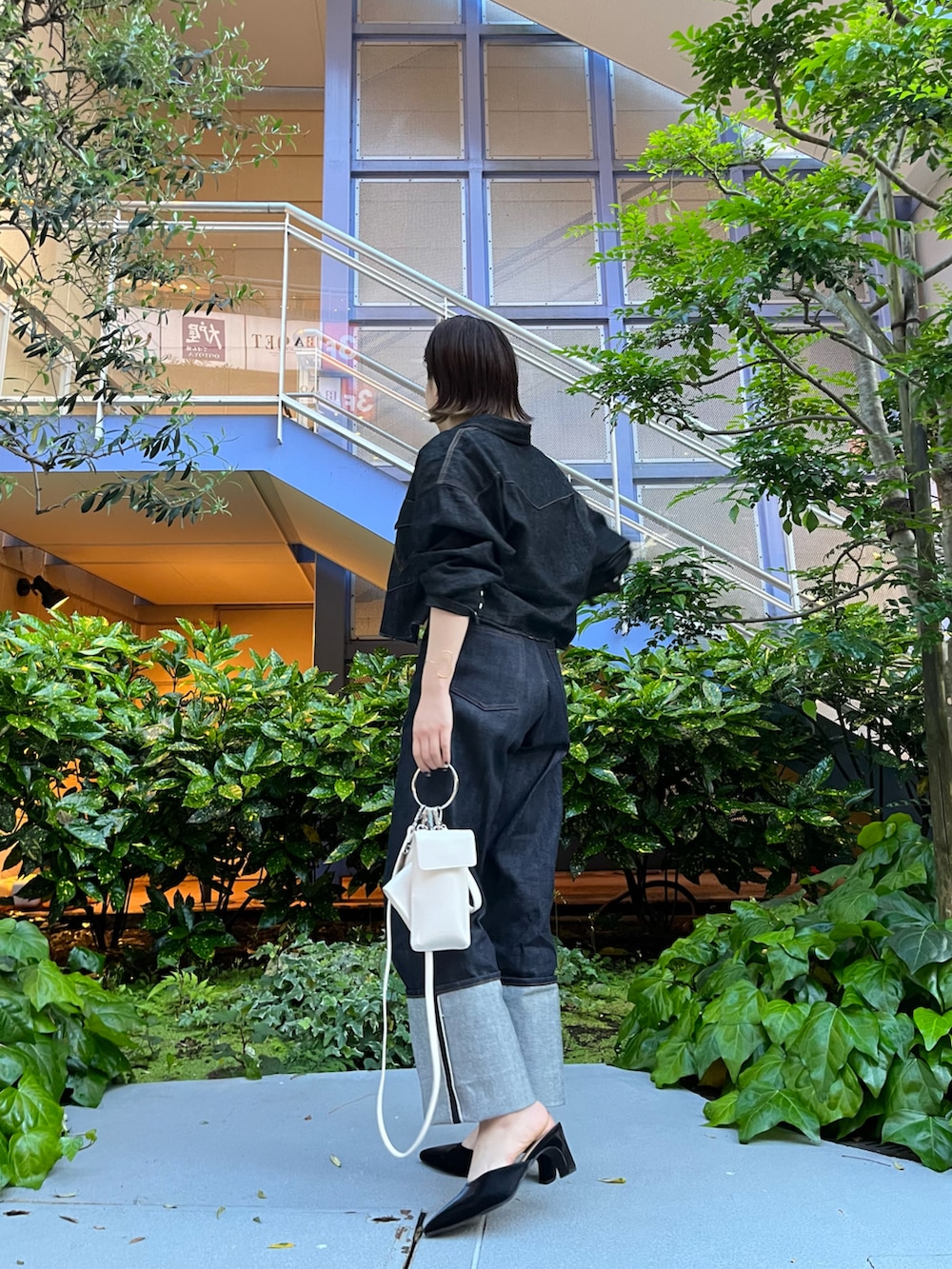 ホワイト系のTシャツ/カットソー、ブルー系のデニムパンツ、ブラック系のサンダルを着用したレディースの春コーディネートの3枚目の写真