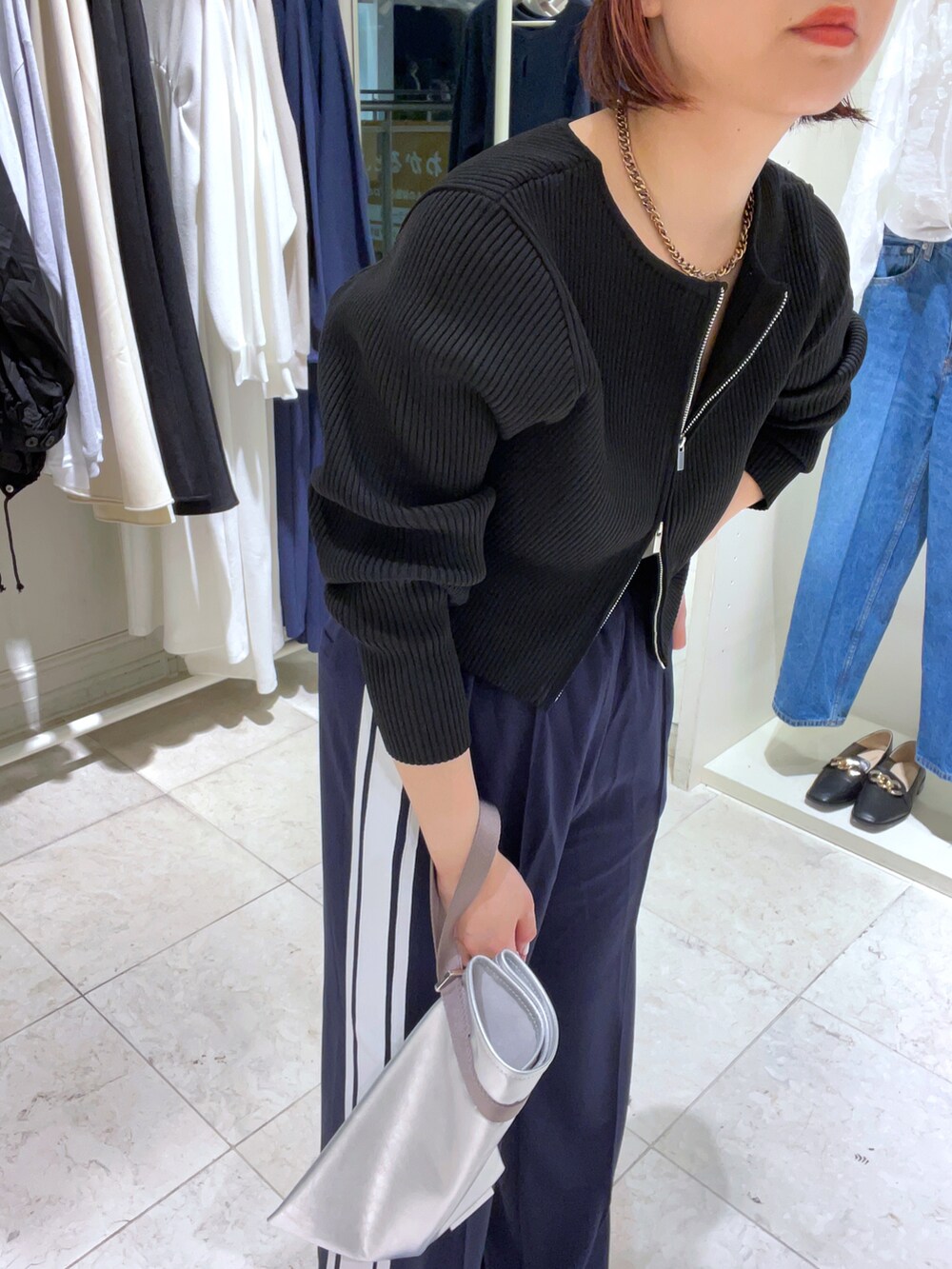 ブラック系のニット/セーター、ブルー系のその他パンツ、シルバー系のパンプスを着用したレディースの春コーディネートの2枚目の写真