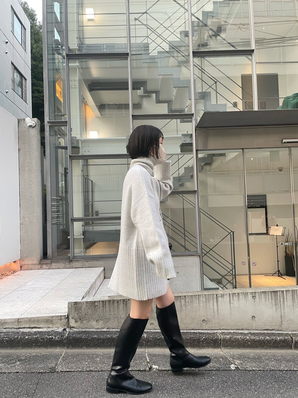 ホワイト系のニット/セーター、ブラック系のショルダーバッグ、ブラック系のブーツを着用したレディースの秋コーディネートの4枚目の写真