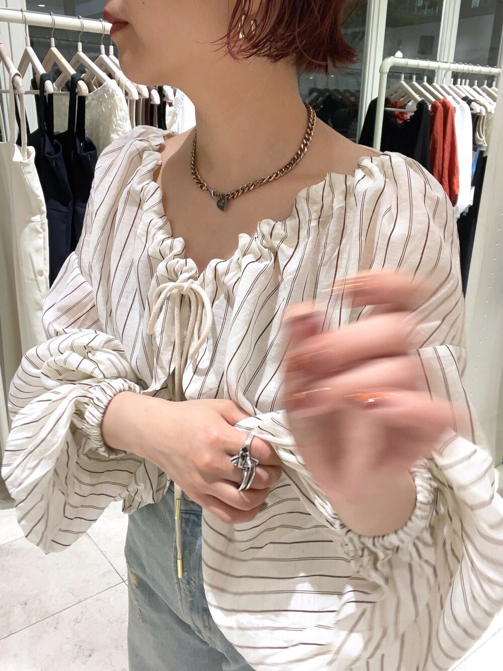 ベージュ系のシャツ/ブラウス、ブルー系のデニムパンツ、ホワイト系のサンダルを着用したレディースの夏コーディネートの2枚目の写真