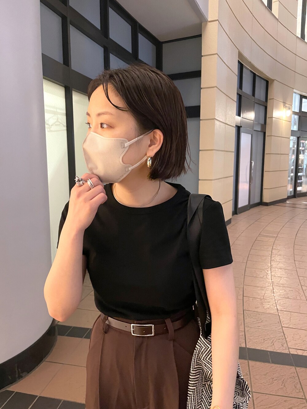 ブラック系のTシャツ/カットソー、ブラウン系のスラックス、ブラック系のサンダルを着用したレディースの夏コーディネートの2枚目の写真