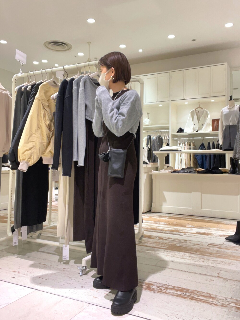 ブラウン系のワンピース、ブラック系のショルダーバッグ、ブラック系のベストを着用したレディースの秋コーディネートの2枚目の写真