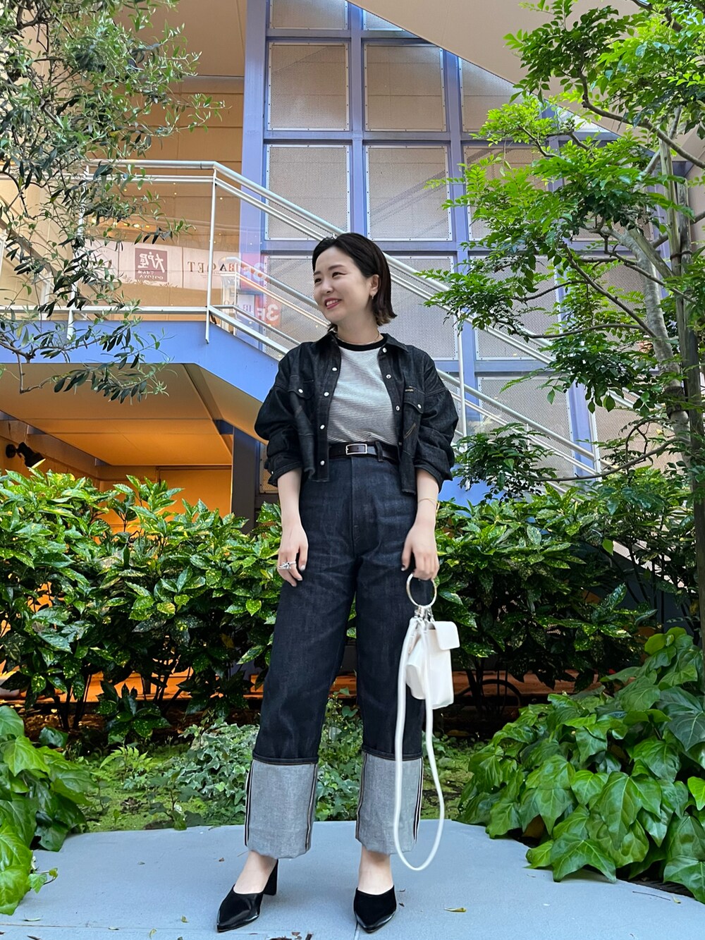 ホワイト系のTシャツ/カットソー、ブルー系のデニムパンツ、ブラック系のサンダルを着用したレディースの春コーディネートの2枚目の写真