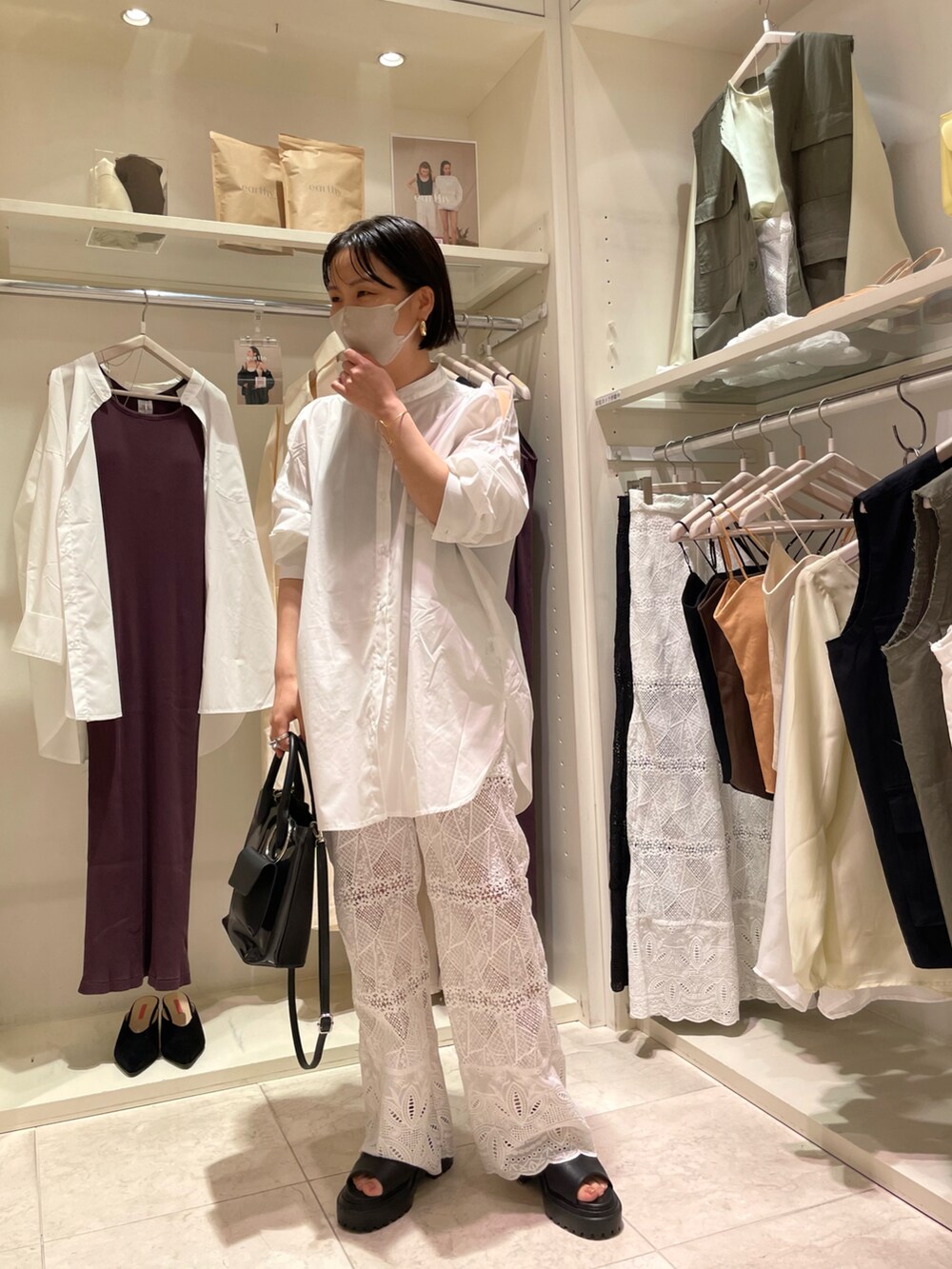 ブラック系のショルダーバッグ、ホワイト系のシャツ/ブラウス、ホワイト系のデニムパンツを着用したレディースの夏コーディネートの4枚目の写真