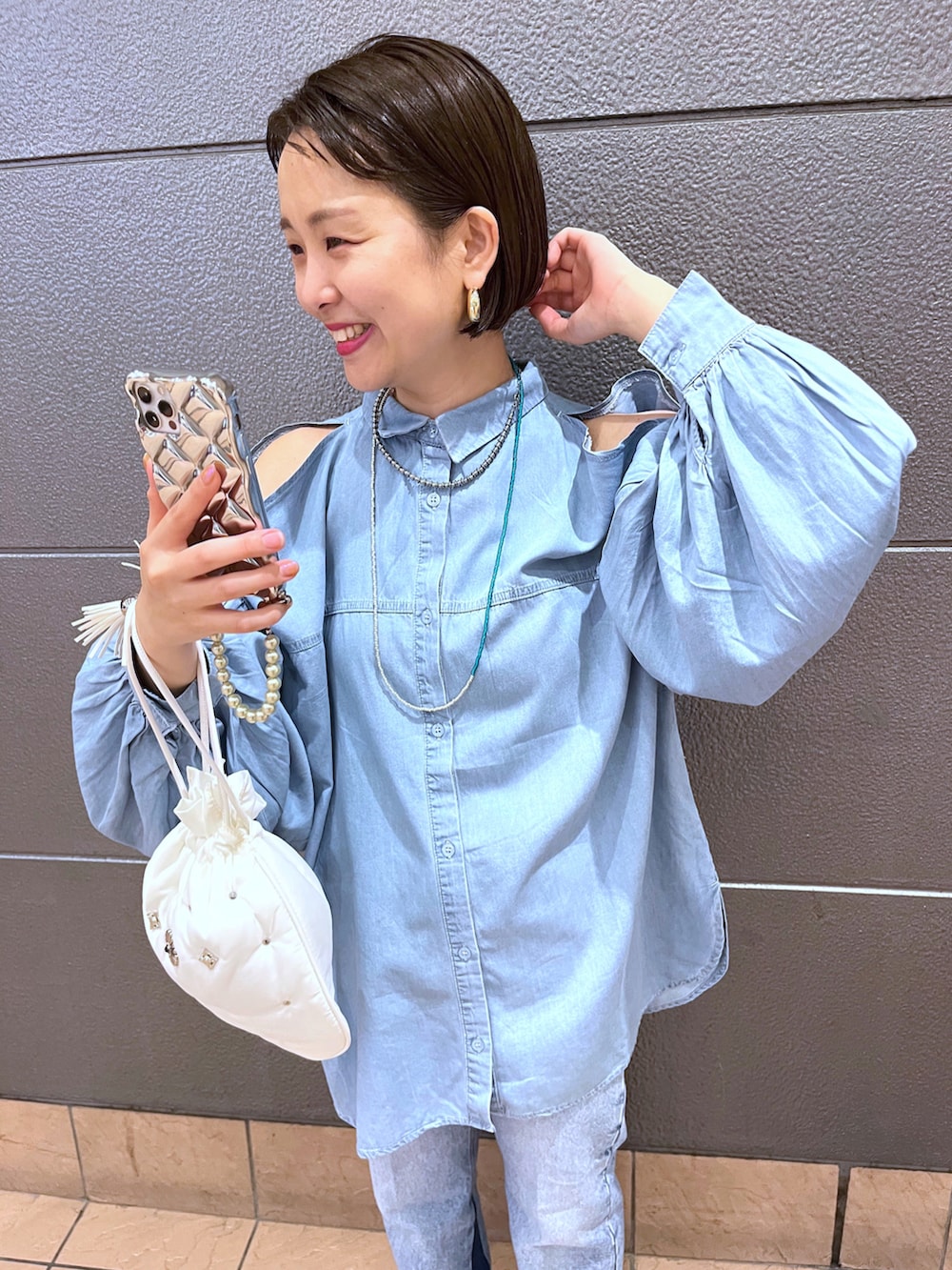 ブルー系のシャツ/ブラウス、ブルー系のデニムパンツ、ブラック系のスリッポンを着用したレディースの夏コーディネートの3枚目の写真