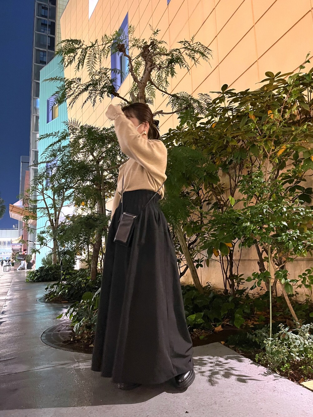 ベージュ系のニット/セーター、ブラック系のスカート、ブラック系のブーツを着用したレディースの秋コーディネートの4枚目の写真