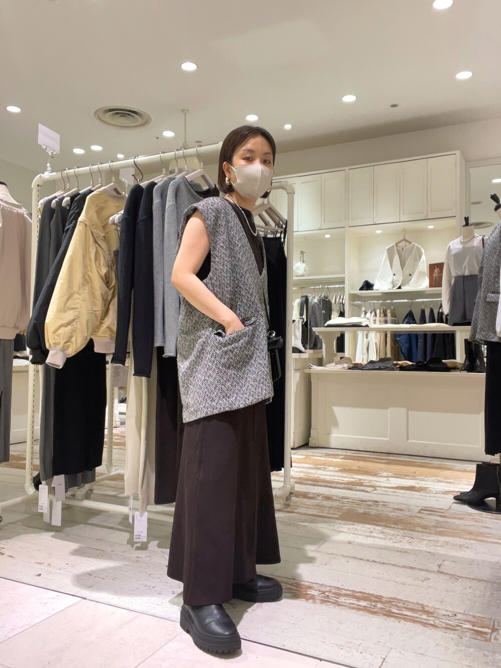 ブラウン系のワンピース、ブラック系のショルダーバッグ、ブラック系のベストを着用したレディースの秋コーディネートの3枚目の写真