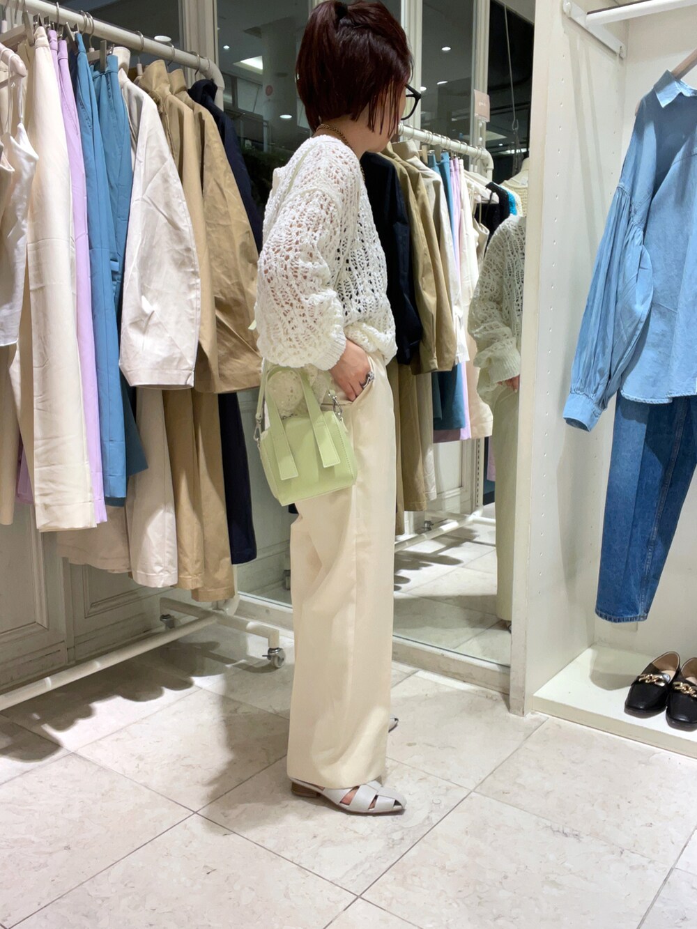 ホワイト系のニット/セーター、ホワイト系のスラックス、ホワイト系のサンダルを着用したレディースの春コーディネートの2枚目の写真