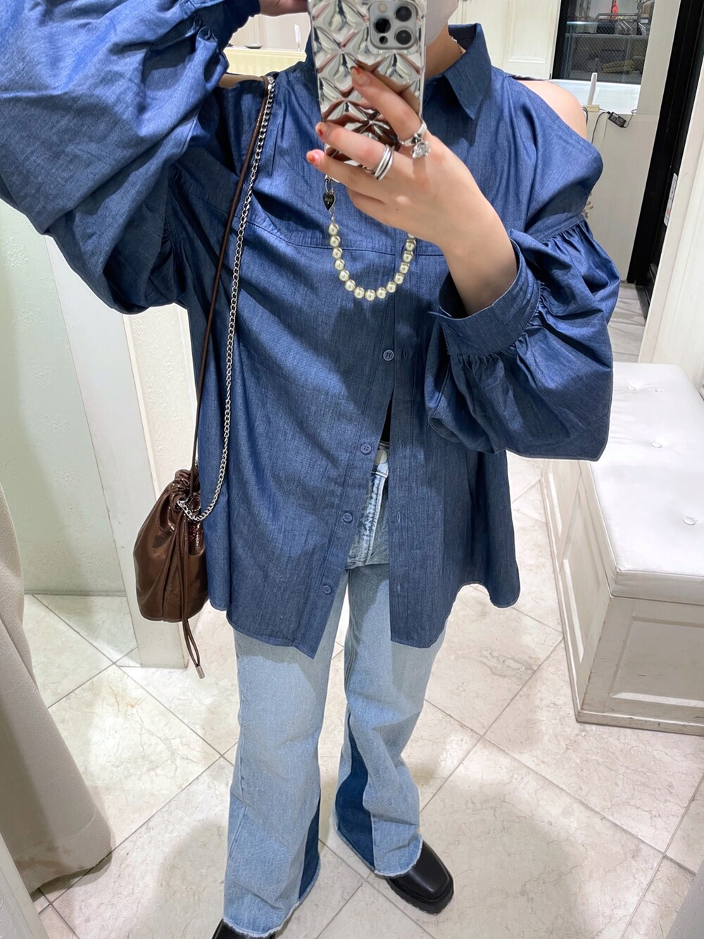 ブルー系のシャツ/ブラウス、ブルー系のデニムパンツ、ブラック系のブーツを着用したレディースの秋コーディネートの3枚目の写真