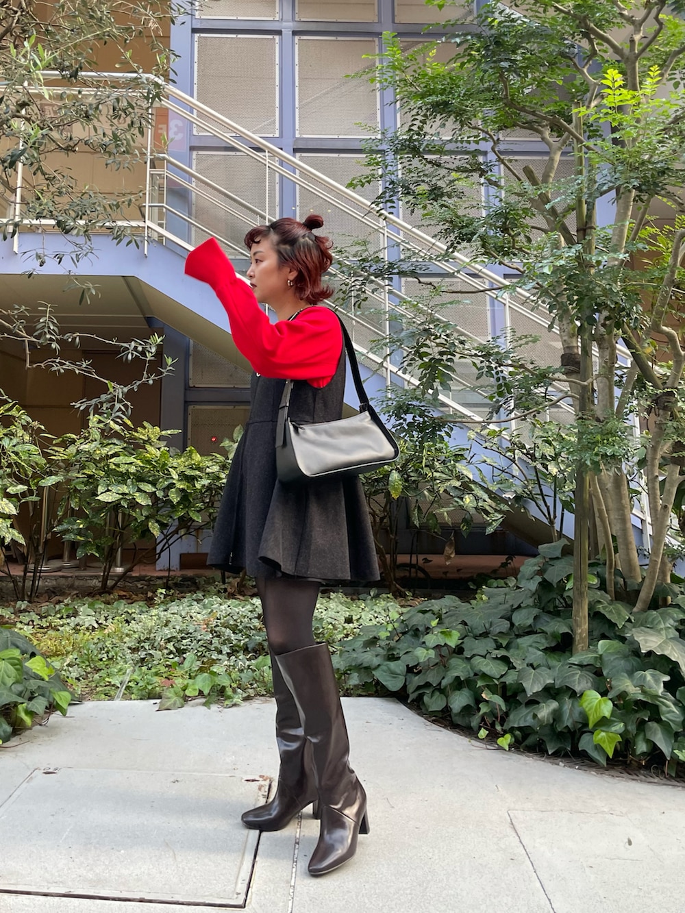 グレー系のベスト、レッド系のニット/セーター、ブラウン系のブーツを着用したレディースの冬コーディネートの3枚目の写真