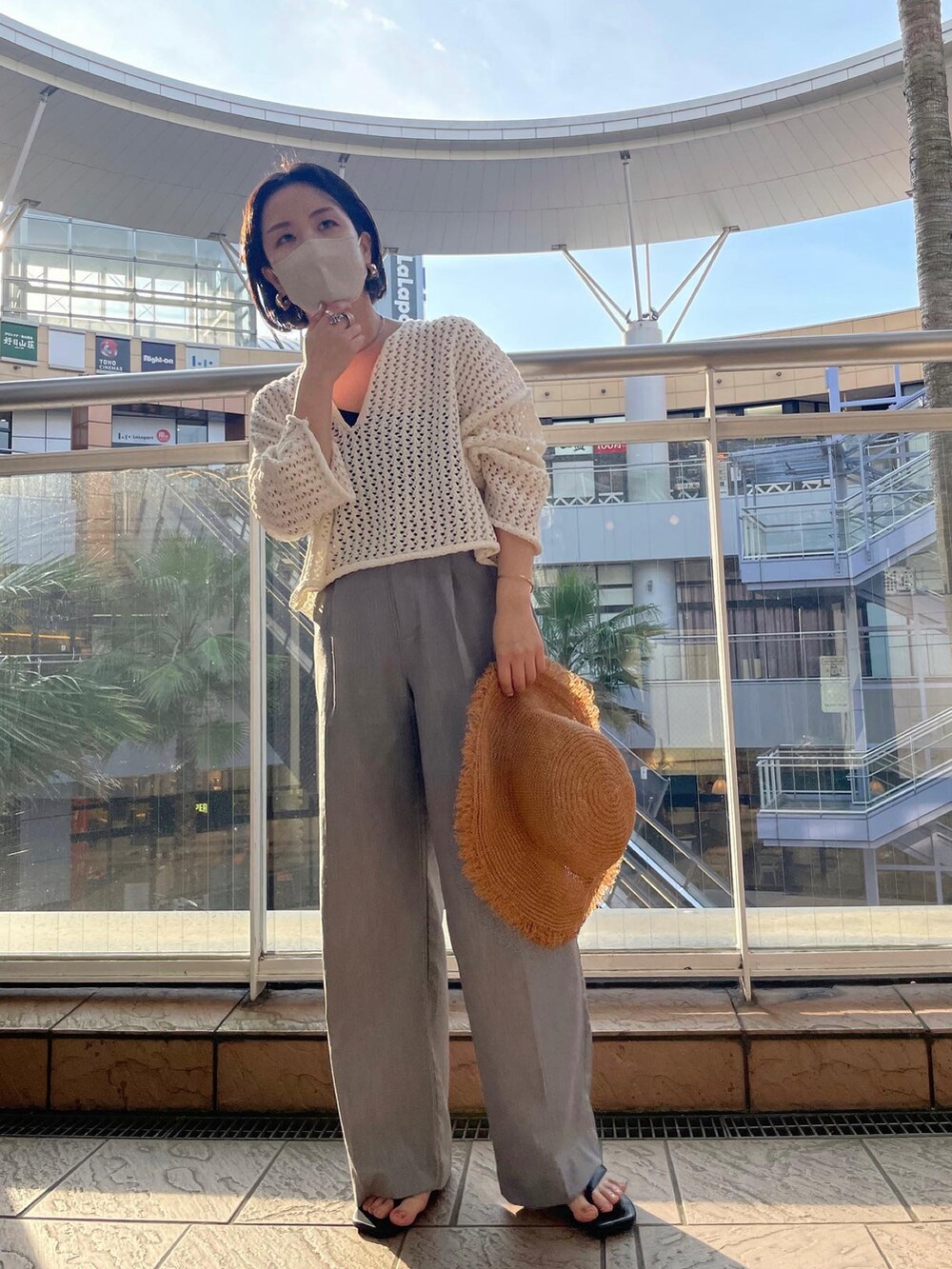 ホワイト系のニット/セーター、グレー系のスラックス、ブラック系のサンダルを着用したレディースの夏コーディネートの3枚目の写真