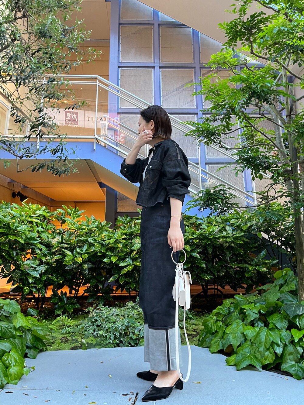 ホワイト系のTシャツ/カットソー、ブルー系のデニムパンツ、ブラック系のサンダルを着用したレディースの春コーディネートの4枚目の写真