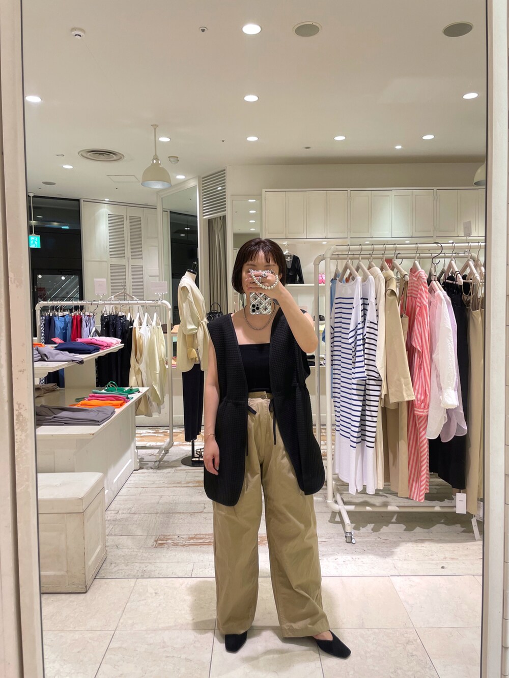 ブラック系のTシャツ/カットソー、ベージュ系のチノパンツを着用したレディースの夏コーディネートの3枚目の写真