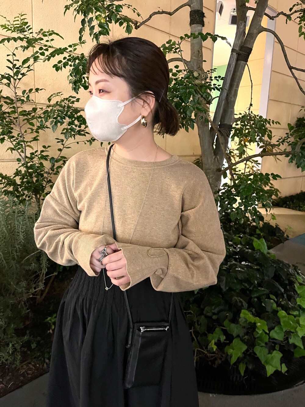 ベージュ系のニット/セーター、ブラック系のスカート、ブラック系のブーツを着用したレディースの秋コーディネートの3枚目の写真