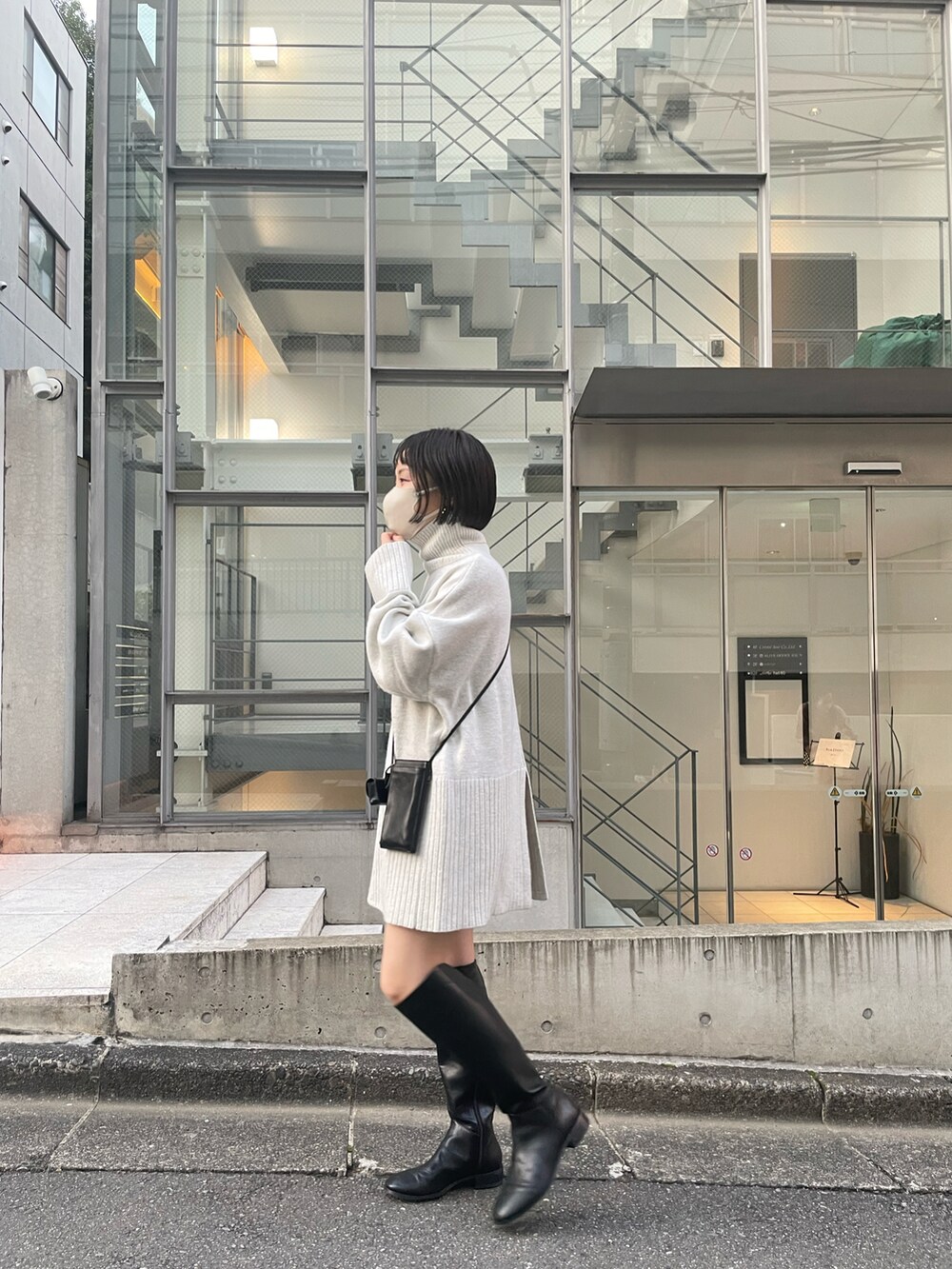 ホワイト系のニット/セーター、ブラック系のショルダーバッグ、ブラック系のブーツを着用したレディースの秋コーディネートの3枚目の写真