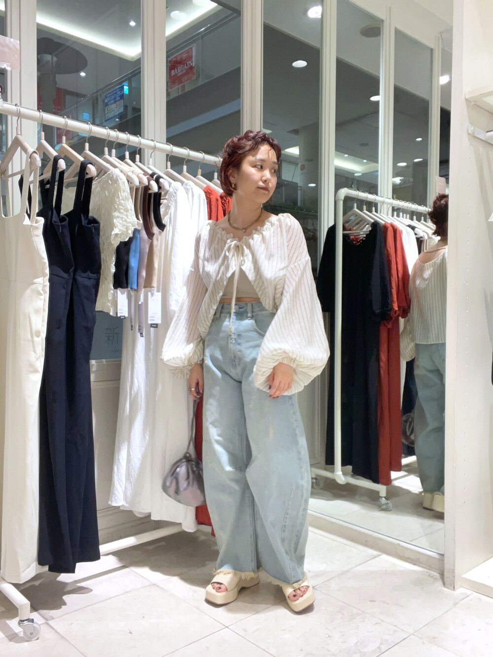 ベージュ系のシャツ/ブラウス、ブルー系のデニムパンツ、ホワイト系のサンダルを着用したレディースの夏コーディネートの4枚目の写真