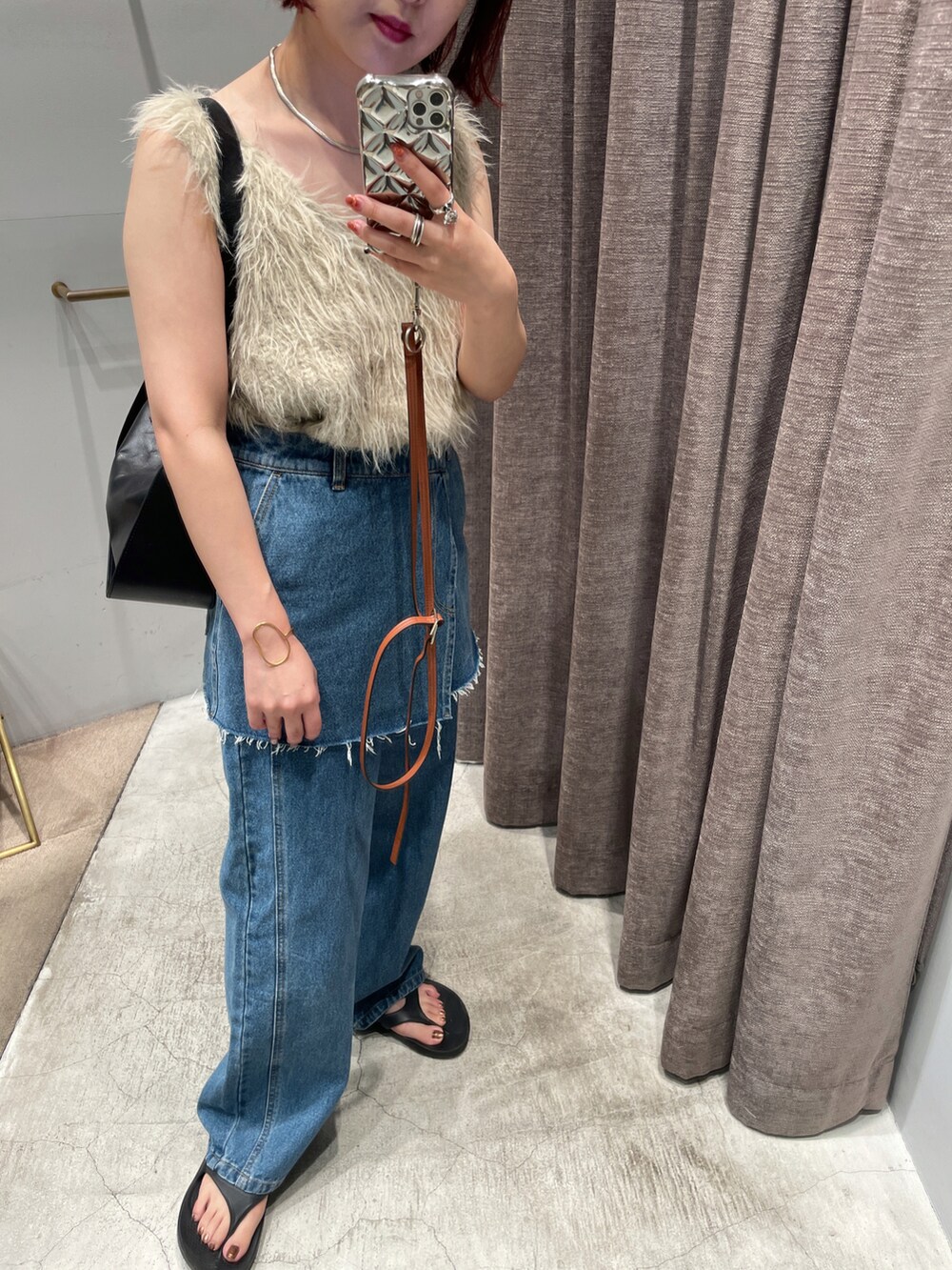 ベージュ系のベスト、ブラック系のショルダーバッグを着用したレディースの秋コーディネートの2枚目の写真