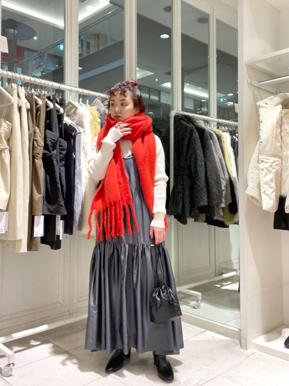 グレー系のワンピース/ドレス、ホワイト系のニット/セーター、ブラック系のブーツを着用したレディースの冬コーディネートの2枚目の写真