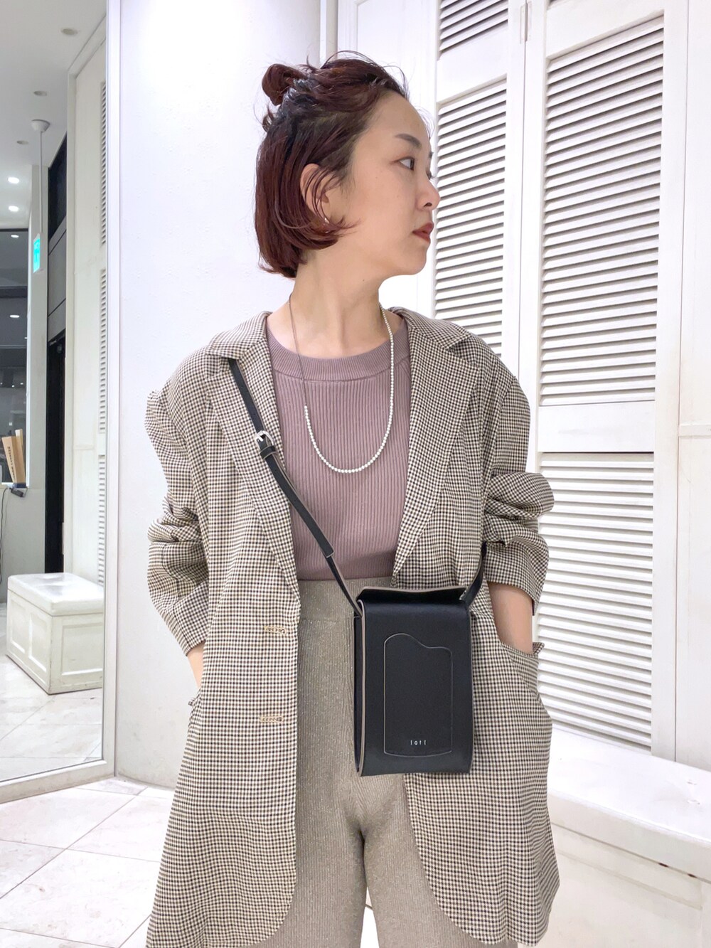 ベージュ系のテーラードジャケット、ブラウン系のキャミソール、ベージュ系のその他パンツを着用したレディースの夏コーディネートの2枚目の写真