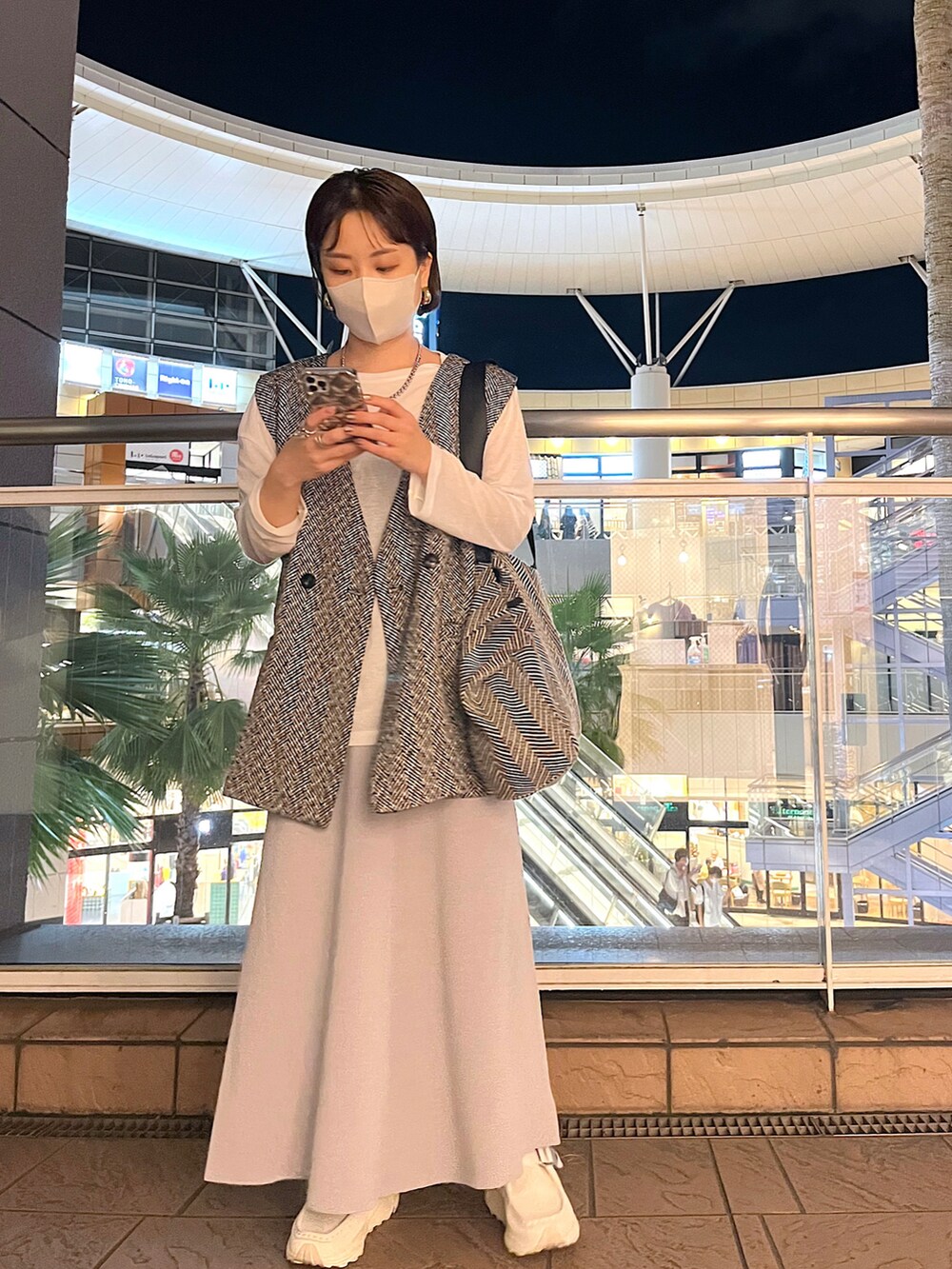 ホワイト系のTシャツ/カットソー、ブラック系のベスト、グレー系のスカートを着用したレディースの秋コーディネートの4枚目の写真