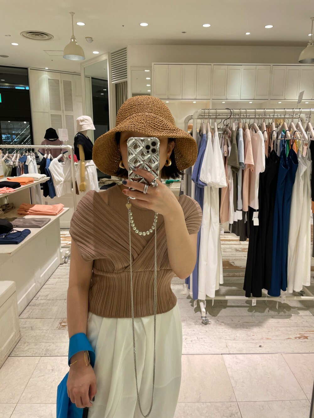 イエロー系のニット/セーター、ホワイト系のその他パンツ、ブルー系のハンドバッグを着用したレディースの夏コーディネートの2枚目の写真