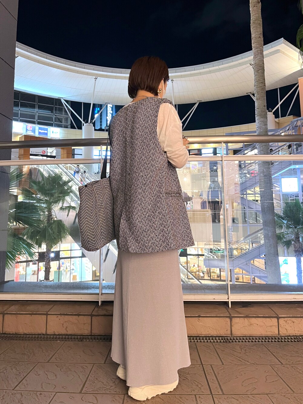 ホワイト系のTシャツ/カットソー、ブラック系のベスト、グレー系のスカートを着用したレディースの秋コーディネートの3枚目の写真