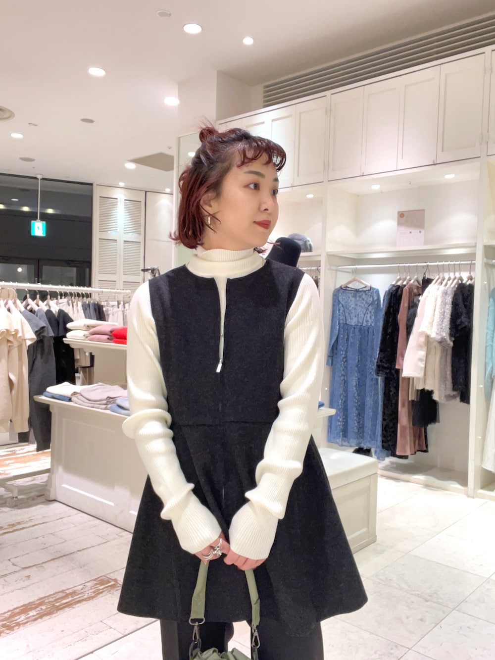 ホワイト系のニット/セーター、グレー系のベスト、ブラック系のスラックスを着用したレディースの冬コーディネートの2枚目の写真
