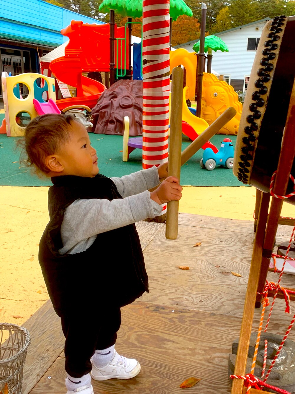 ホワイト系のスニーカー、ブラック系のダウンベスト、グレー系のスウェットを着用したキッズの秋コーディネートの2枚目の写真