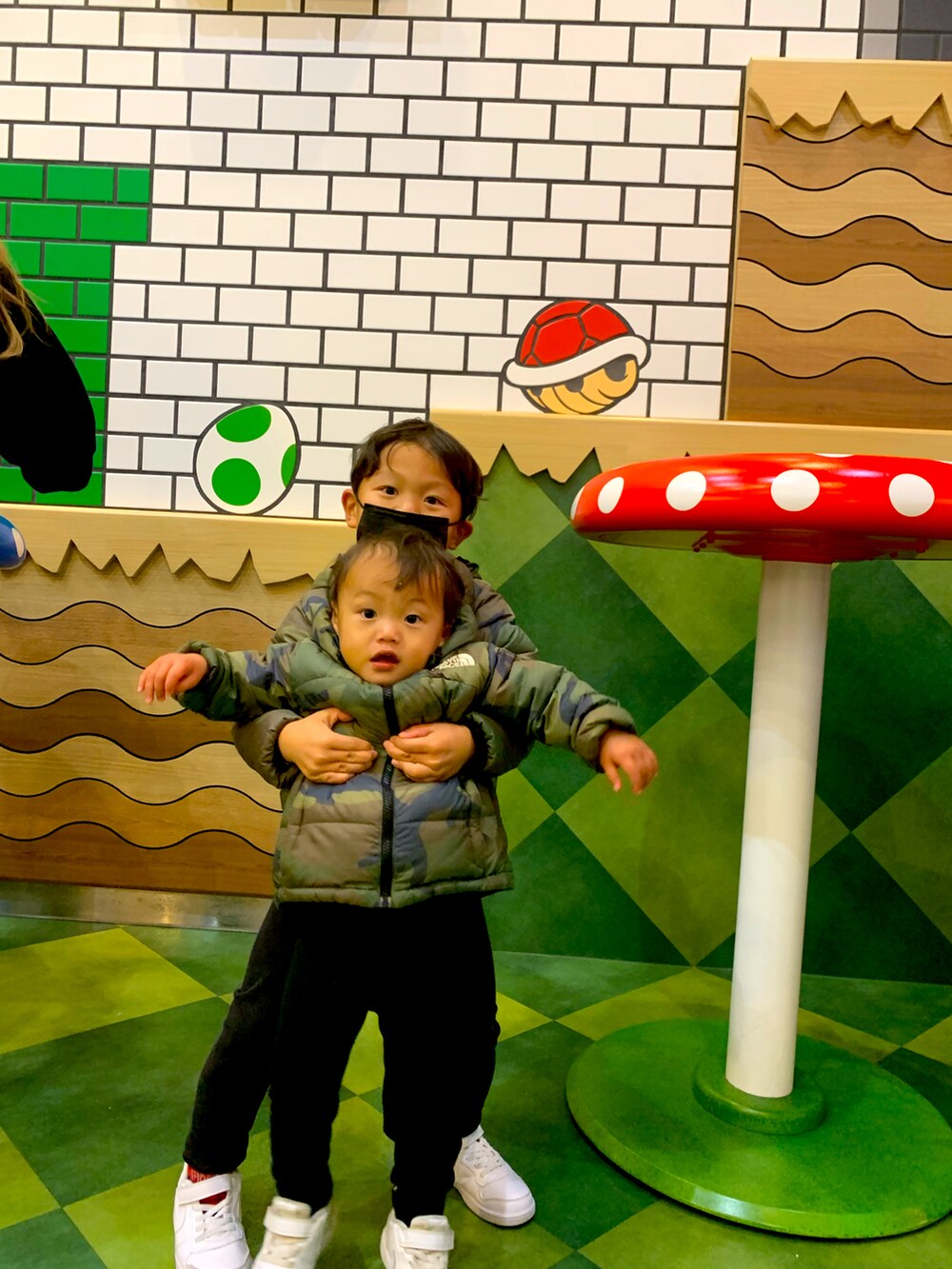 グリーン系のダウンジャケット/コート、グリーン系のダウンジャケット/コート、ホワイト系のスニーカーを着用したキッズの夏コーディネートの2枚目の写真