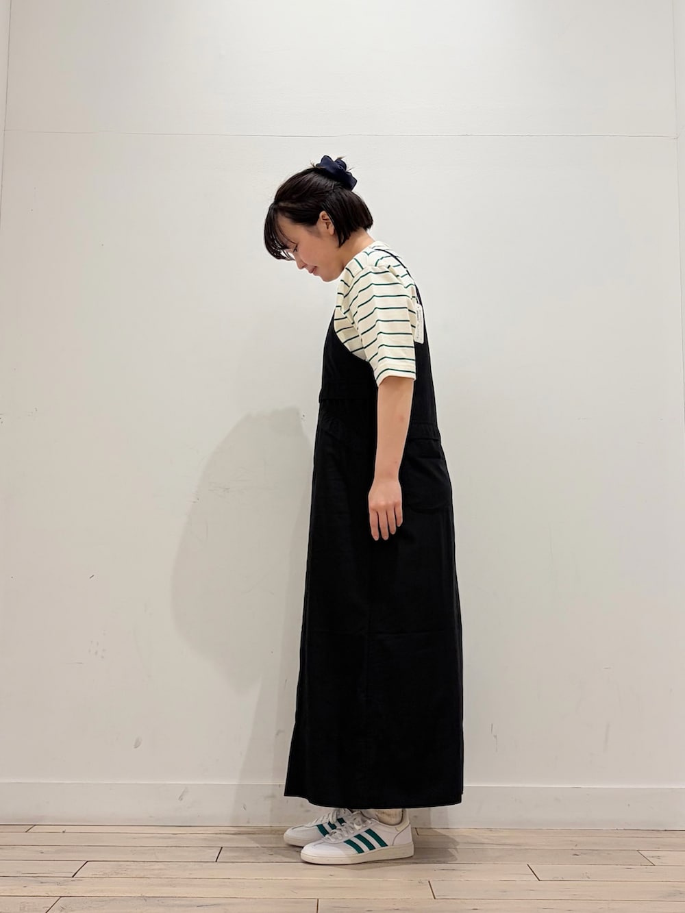 ベージュ系のTシャツ/カットソー、ホワイト系のスニーカー、ブラック系のワンピースを着用したレディースの春コーディネートの2枚目の写真