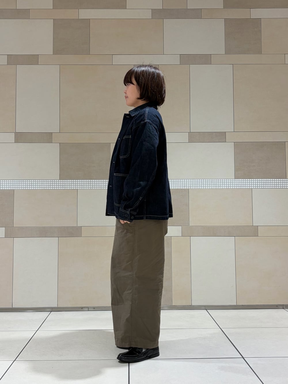 ブルー系のカバーオール、グリーン系のその他パンツ、ホワイト系のニット/セーターを着用したレディースの秋コーディネートの4枚目の写真