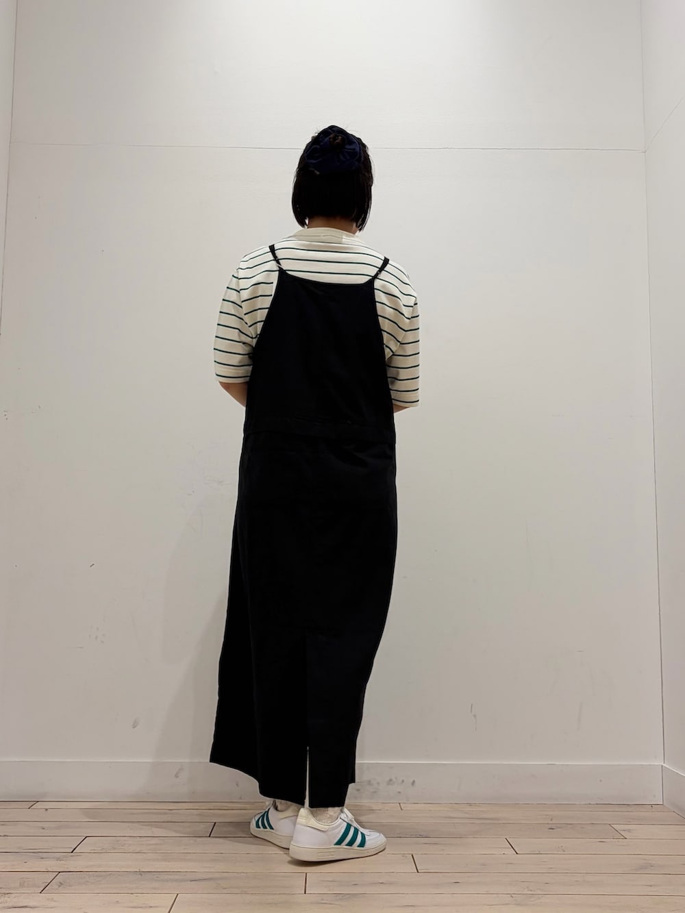 ベージュ系のTシャツ/カットソー、ホワイト系のスニーカー、ブラック系のワンピースを着用したレディースの春コーディネートの3枚目の写真