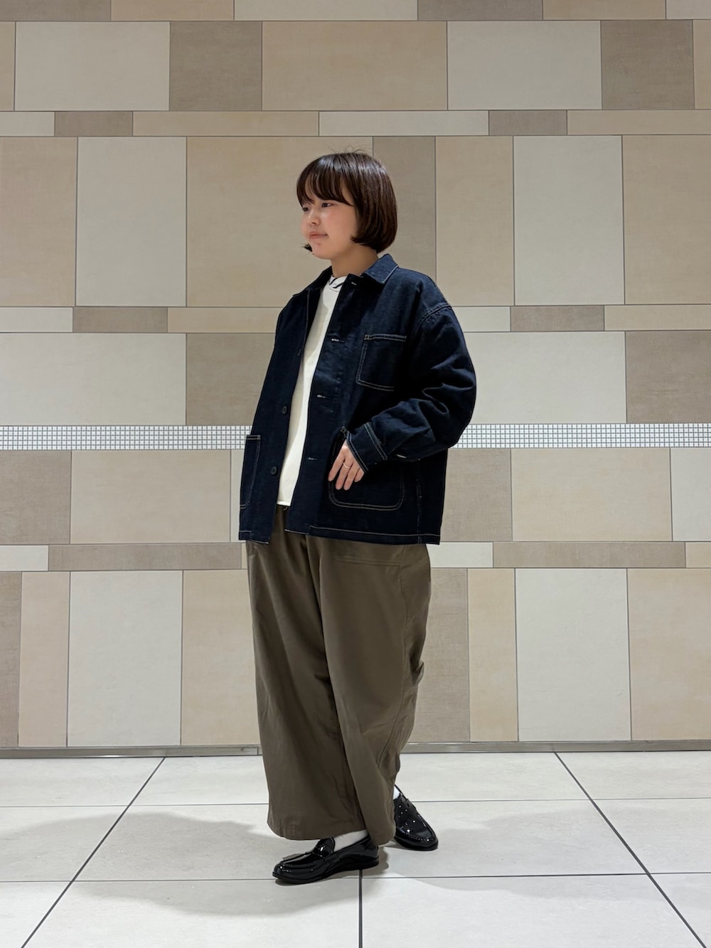 ブルー系のカバーオール、グリーン系のその他パンツ、ホワイト系のニット/セーターを着用したレディースの秋コーディネートの2枚目の写真