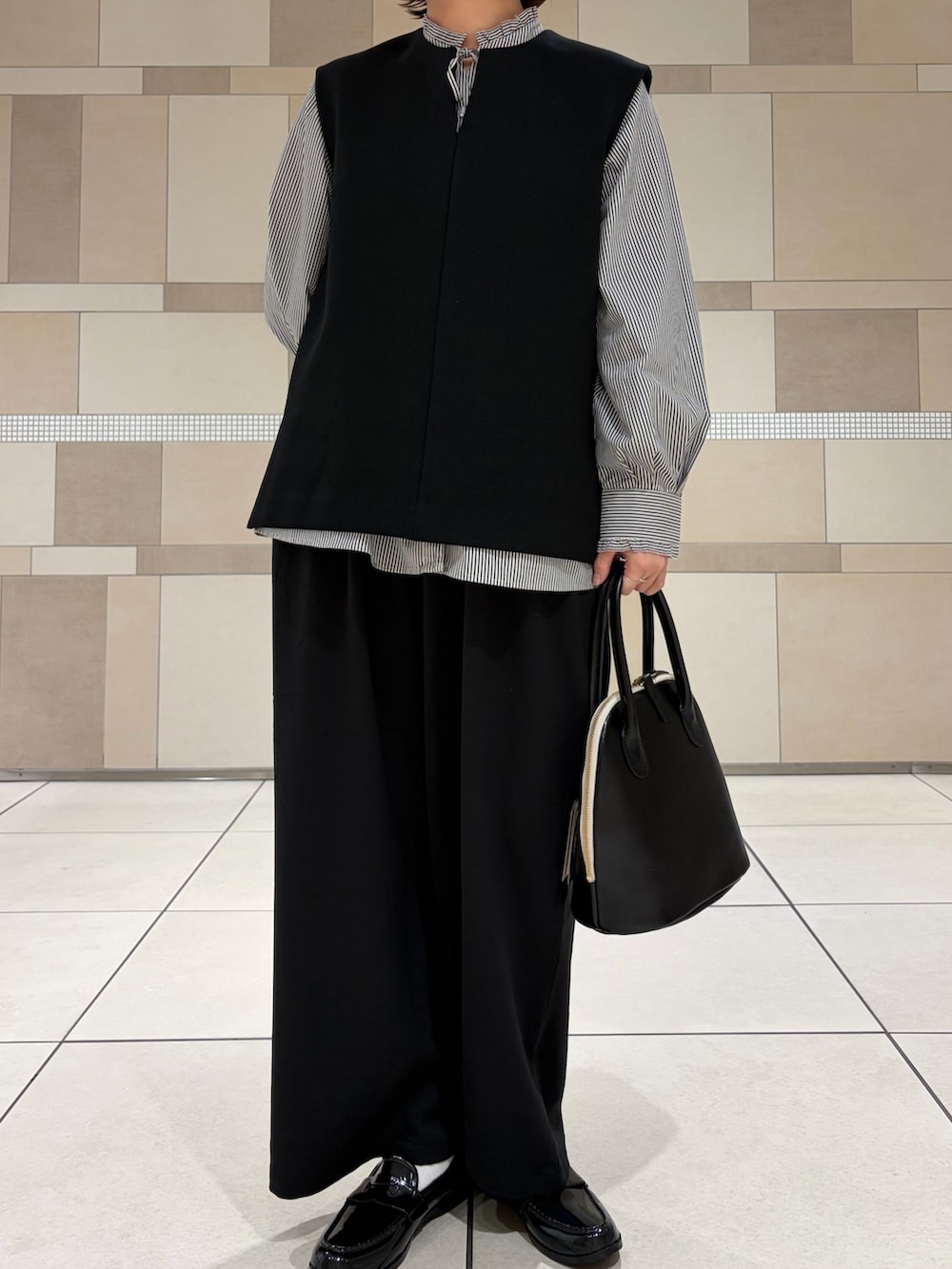 ブラック系のシャツ/ブラウス、ブラック系のその他パンツ、ブラック系のレインシューズを着用したレディースの秋コーディネートの4枚目の写真