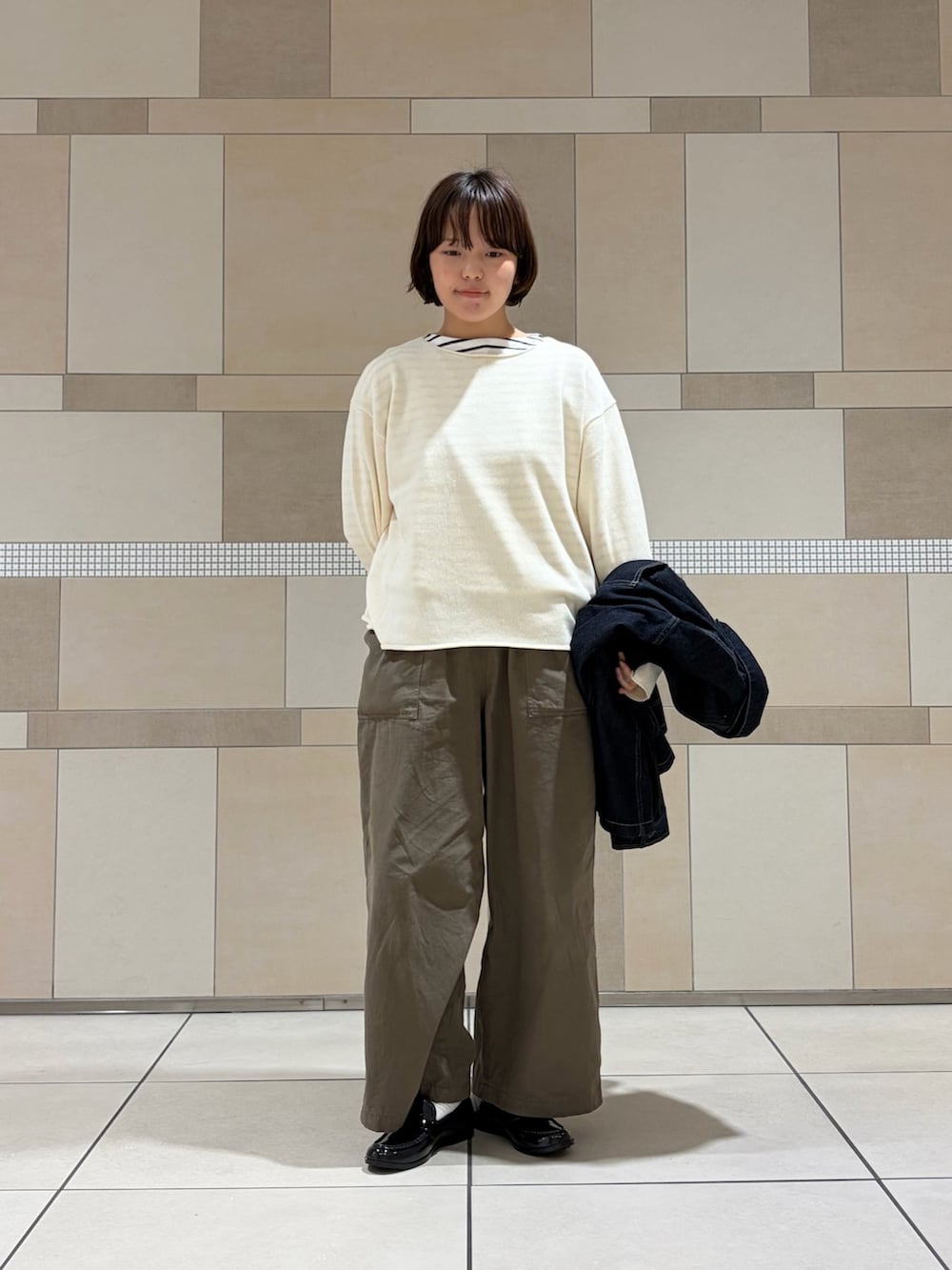 ブルー系のカバーオール、グリーン系のその他パンツ、ホワイト系のニット/セーターを着用したレディースの秋コーディネートの3枚目の写真