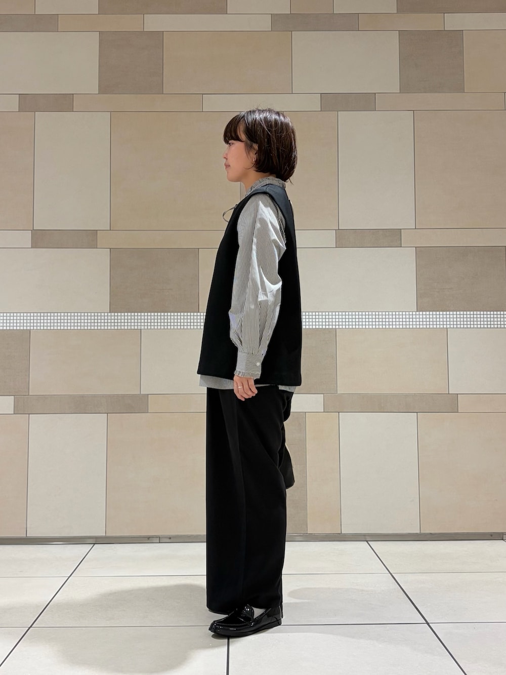 ブラック系のシャツ/ブラウス、ブラック系のその他パンツ、ブラック系のレインシューズを着用したレディースの秋コーディネートの3枚目の写真