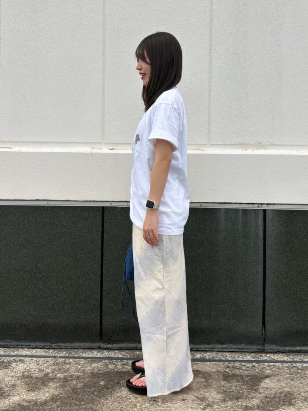 ホワイト系のTシャツ/カットソー、ブルー系のスカート、ブルー系のハンドバッグを着用したレディースの夏コーディネートの2枚目の写真