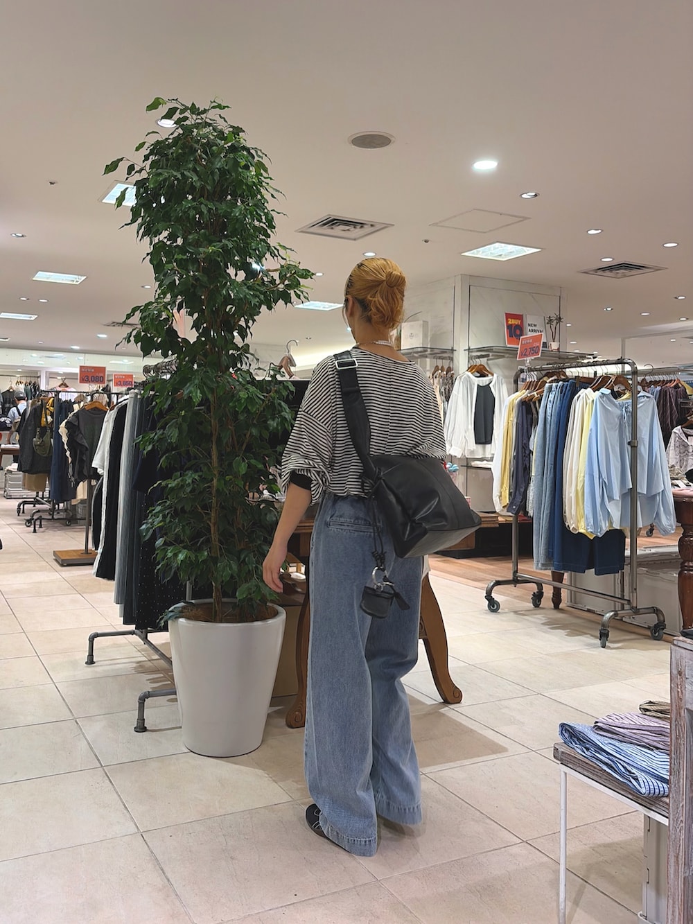 ブルー系のデニムパンツ、ブラック系のショルダーバッグを着用したレディースの春コーディネートの2枚目の写真