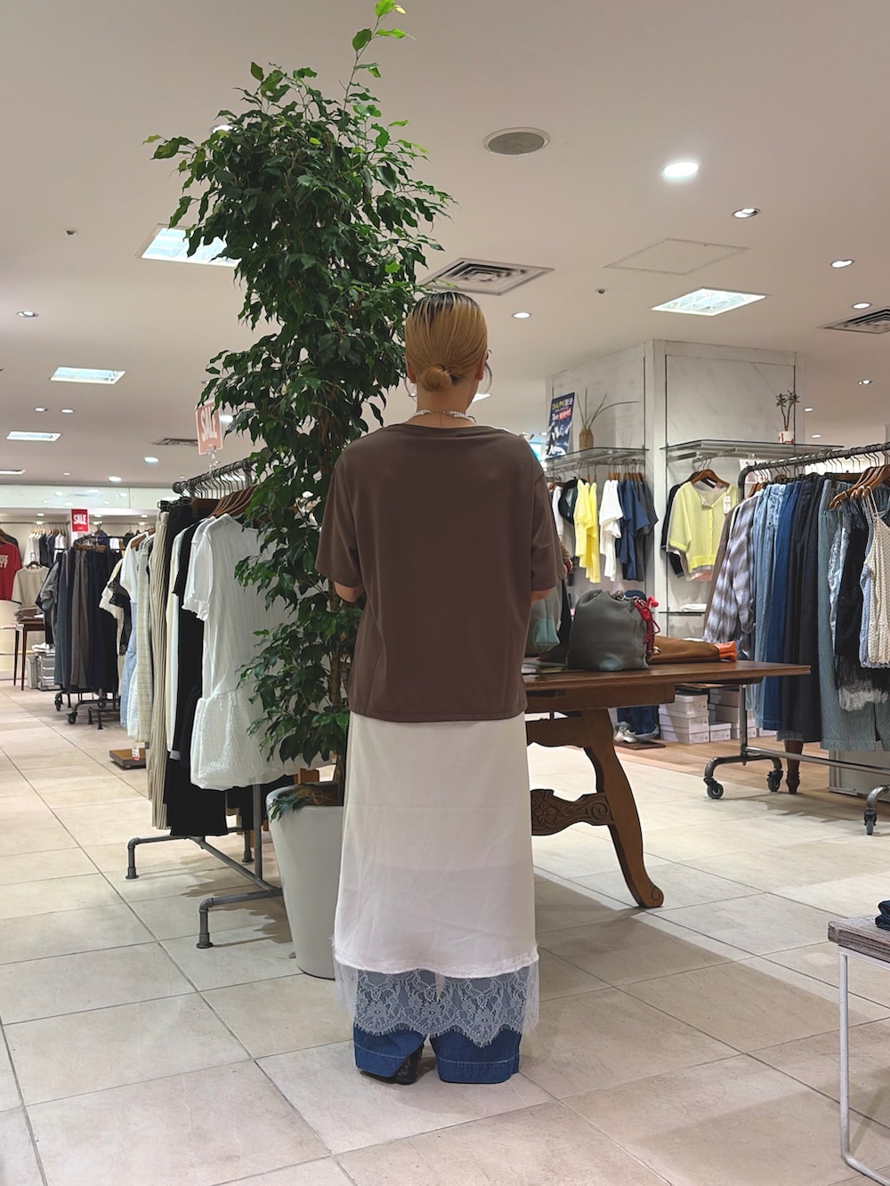 ブラウン系のTシャツ/カットソー、ホワイト系のスカート、ブルー系のデニムパンツを着用したレディースの夏コーディネートの2枚目の写真