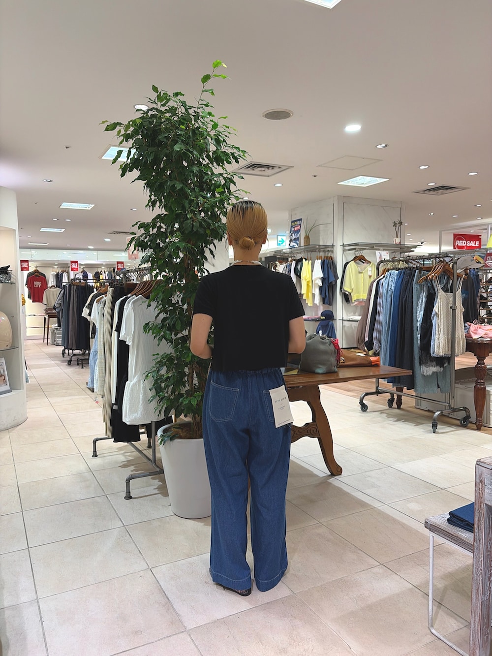 ブラック系のTシャツ/カットソー、ベージュ系のショルダーバッグ、ブルー系のデニムパンツを着用したレディースの夏コーディネートの2枚目の写真