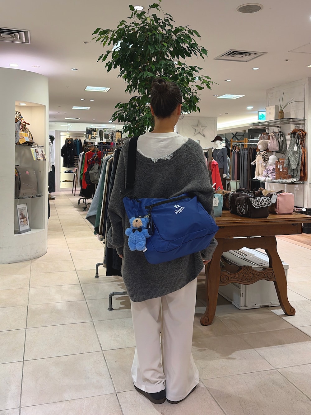 ホワイト系のTシャツ/カットソー、グレー系のニット/セーター、ブルー系のショルダーバッグを着用したレディースの秋コーディネートの3枚目の写真