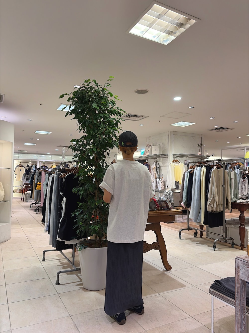 グレー系のTシャツ/カットソー、ブラック系のスカート、グレー系のキャップを着用したレディースの春コーディネートの2枚目の写真
