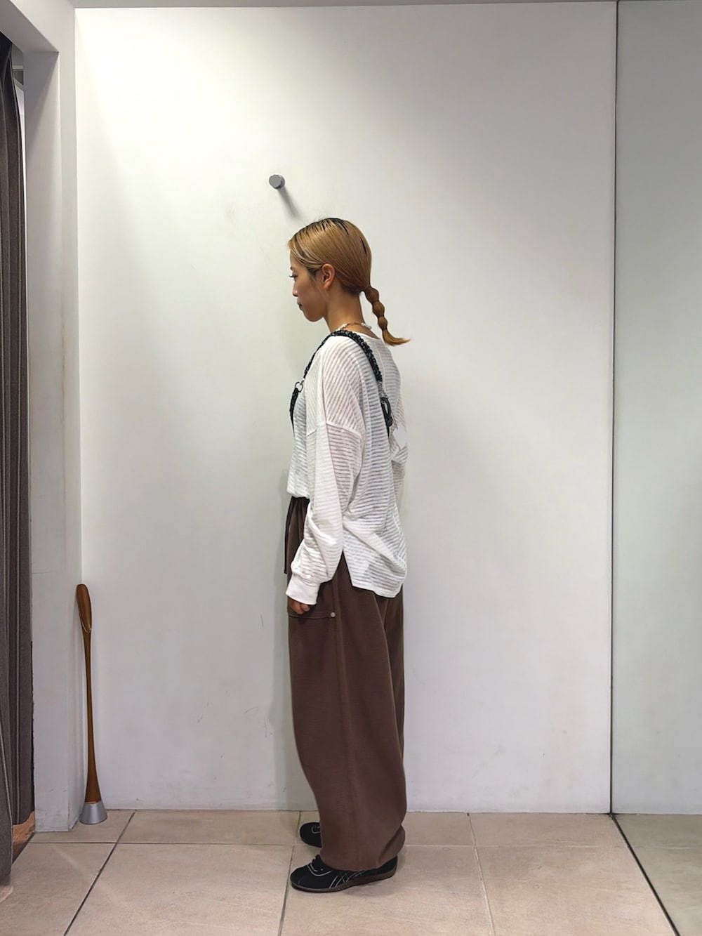 ホワイト系のTシャツ/カットソー、ブラウン系のスウェットパンツ、ブラック系のスマホグッズを着用したレディースの夏コーディネートの3枚目の写真